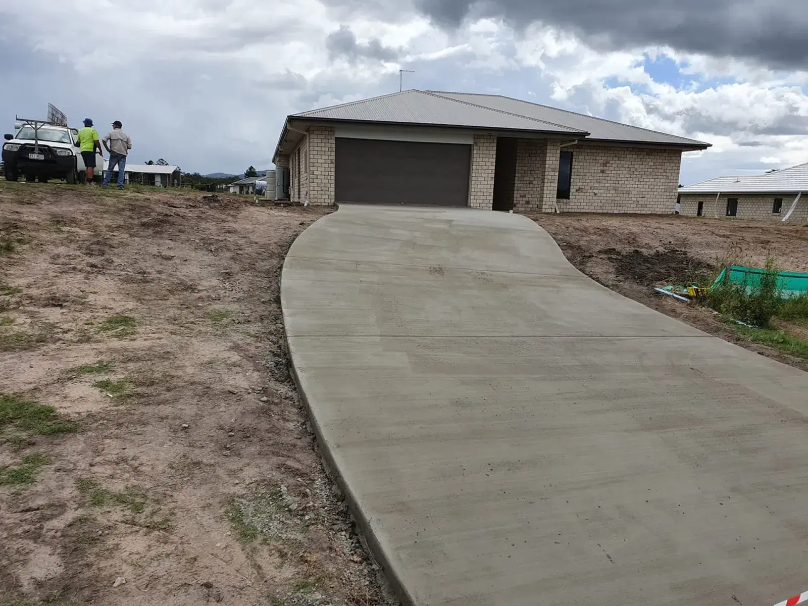 Plain concrete rural driveway leading to a residential garage